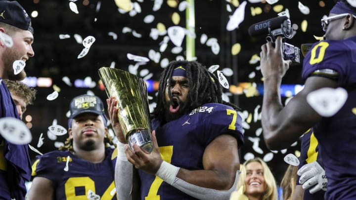 Michigan running back Donovan Edwards picks up the trophy to celebrate 34-13 win over Washington at the national championship game at NRG Stadium in Houston on Monday, Jan. 8, 2024.