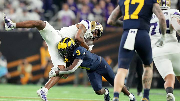Washington wide receiver Ja'Lynn Polk is tackled by Michigan defensive back Rod Moore during the second half of the College Football Playoff national championship game against Washington at NRG Stadium in Houston, Texas on Monday, Jan. 8, 2024.