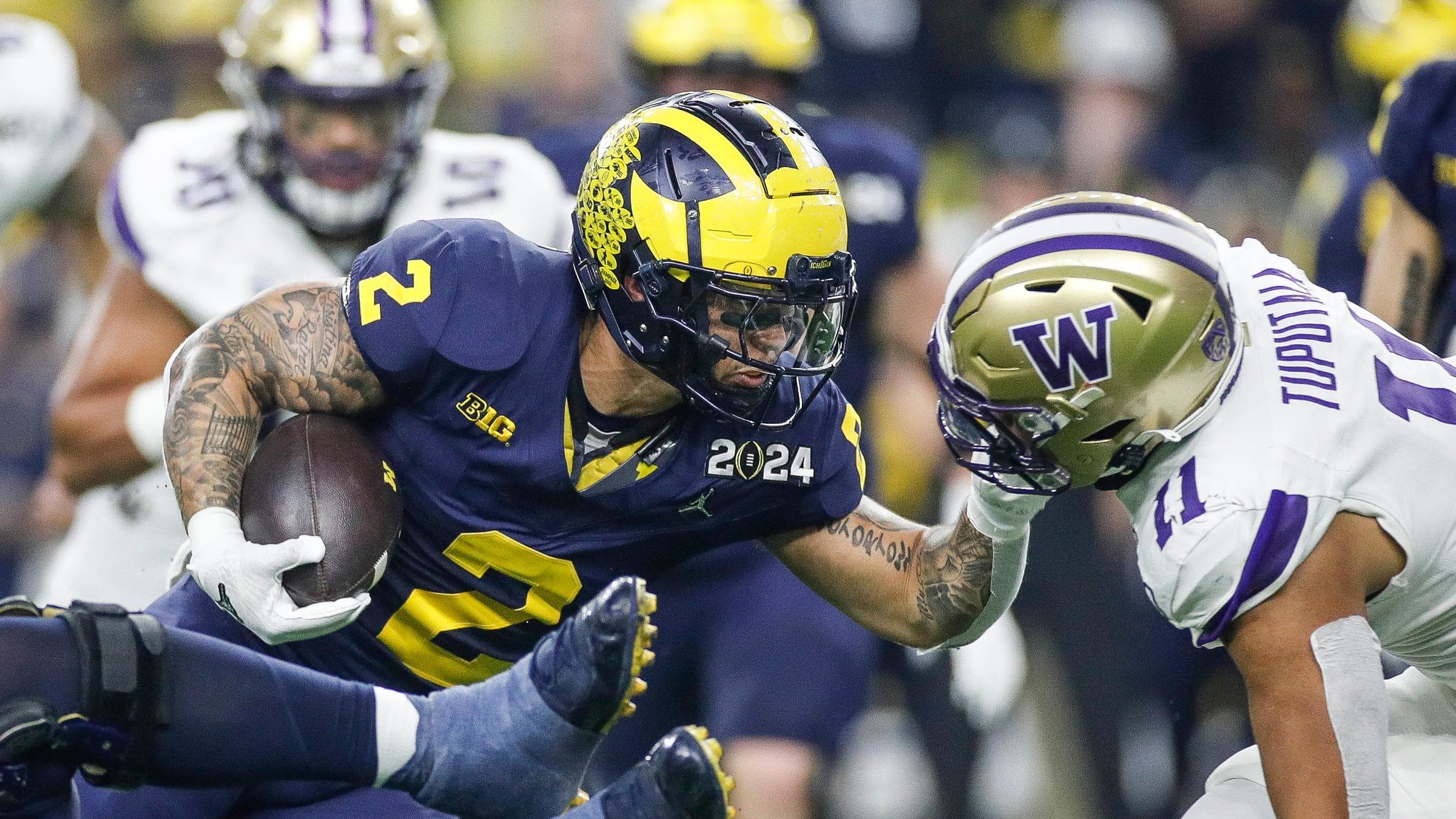 Michigan running back Blake Corum runs against Washington linebacker Alphonzo Tuputala.