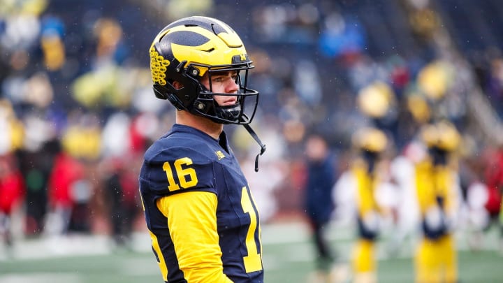 Michigan quarterback Davis Warren (16) warms up before the Indiana game at Michigan Stadium in Ann Arbor on Saturday, Oct. 14, 2023.