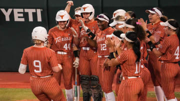 Teammates cheer for Texas infielder Joley Mitchell (9) after she scored a home run as the Longhorns