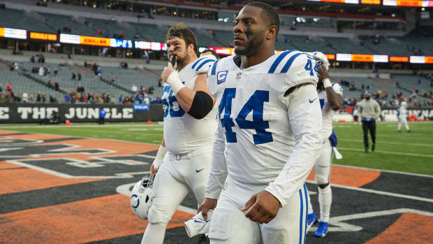 Colts players Zaire Franklin and Quenton Nelson (all white jerseys with blue numbers) walk off the football field. 