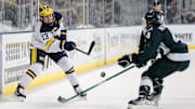 Michigan center TJ Hughes makes a pass against Michigan State defenseman Nash Nienhuis during the third period at Yost Ice Arena in Ann Arbor on Friday, Feb. 9, 2024.