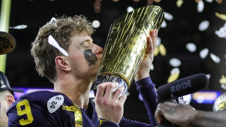 Michigan quarterback J.J. McCarthy misses the trophy to celebrate 34-13 win over Washington at the