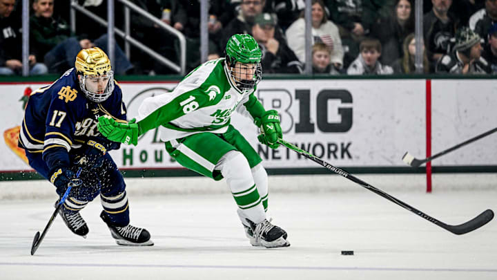 Michigan State's Ryker Lee, right, fends off Notre Dame's Pano Fimis during the third period on Thursday, Feb. 19, 2026, at the Munn Ice Arena in East Lansing.