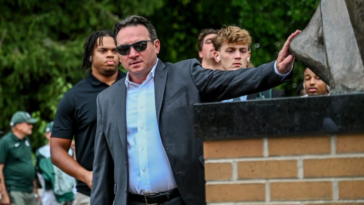 Michigan State's head coach Jonathan Smith touches the foot of the Sparty statue before the game against Florida Atlantic on Friday, Aug. 30, 2024, outside Spartan Stadium in East Lansing.