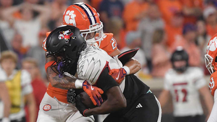 Nov 2, 2024; Clemson, South Carolina, USA; Clemson Tigers corner back Avieon Terrell (20) tackles Louisville Cardinals receiver Ja'Corey Brooks (0) during the first quarter at Memorial Stadium. Mandatory Credit: Ken Ruinard-Imagn Images