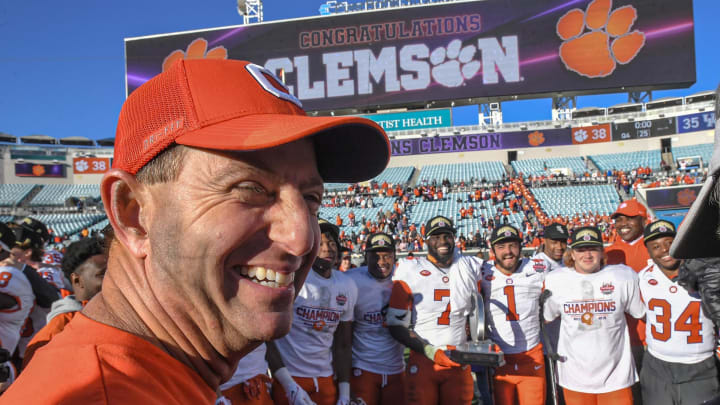 Clemson head coach Dabo Swinney smiles while running backs get a group photo after the TaxSlayer Gator Bowl