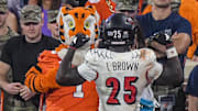 Nov 2, 2024; Clemson, South Carolina, USA; Louisville Cardinals running back Isaac Brown (25) flexes his muscles in front of the Clemson Tigers Tiger mascot after scoring in the fourth quarter at Memorial Stadium. Mandatory Credit: Ken Ruinard-Imagn Images