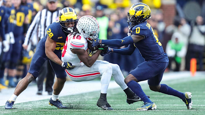 Ohio State wide receiver Marvin Harrison Jr. (18) makes a catch against Michigan defensive back Quinten Johnson (28) and defensive back Mike Sainristil (0) during the second half at Michigan Stadium in Ann Arbor on Saturday, Nov. 25, 2023.