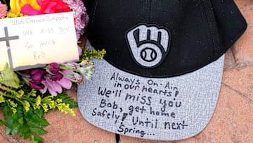 A baseball cap with a message sets at a memorial at the base of a Bob Uecker statue outside American Family Field in Milwaukee on Thursday, Jan. 16, 2025. Uecker, the voice of the team on the airwaves for 54 years, a Baseball Hall of Famer and local, statewide and national icon, died Thursday.