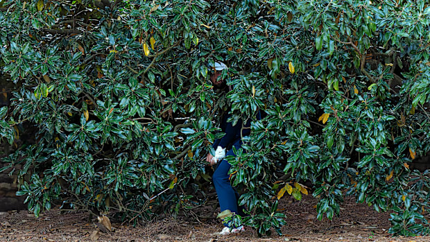 Scottie Scheffler punches out from the trees on Friday at the 2025 Masters.