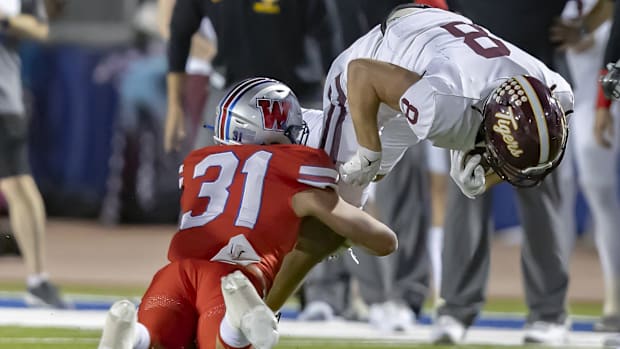 Westlake Chaparrals middle linebacker Elliott Schaper tackles Dripping Springs Tigers wide receiver Nick Tyndall.