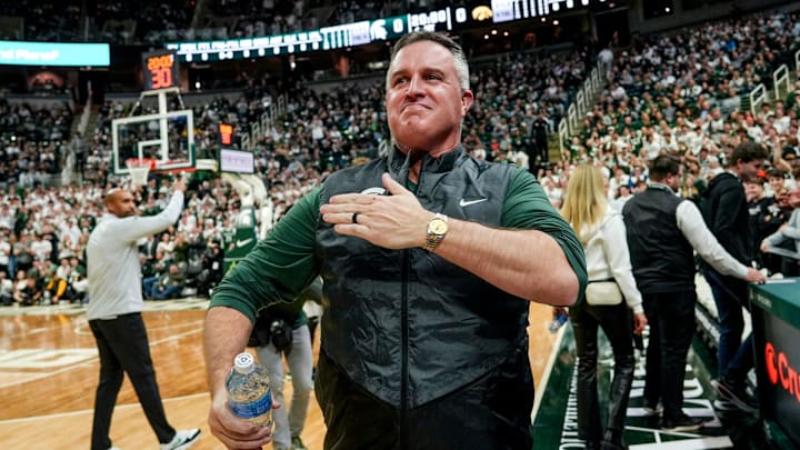 Michigan State's new football coach Pat Fitzgerald pats his heart at the crowd in attendance for the Spartans basketball game against Iowa on Tuesday, Dec. 2, 2025, at the Breslin Center in East Lansing.