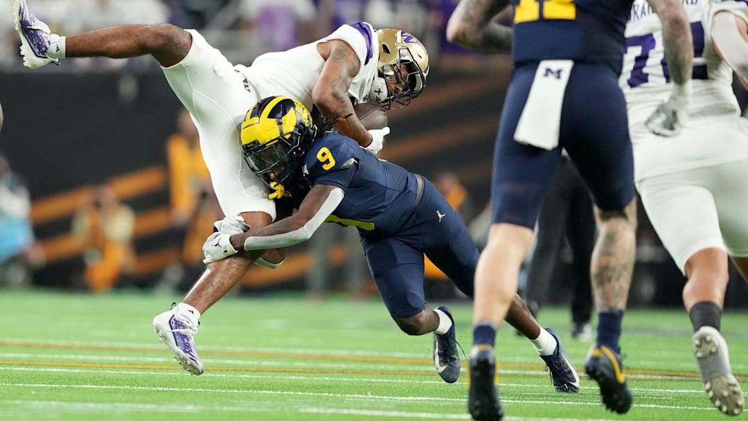 Washington wide receiver Ja'Lynn Polk is tackled by Michigan defensive back Rod Moore during the second half of the College Football Playoff national championship game against Washington at NRG Stadium in Houston, Texas on Monday, Jan. 8, 2024.