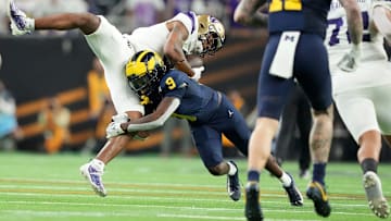 Washington wide receiver Ja'Lynn Polk is tackled by Michigan defensive back Rod Moore during the second half of the College Football Playoff national championship game against Washington at NRG Stadium in Houston, Texas on Monday, Jan. 8, 2024.