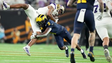 Washington wide receiver Ja'Lynn Polk is tackled by Michigan defensive back Rod Moore during the second half of the College Football Playoff national championship game against Washington at NRG Stadium in Houston, Texas on Monday, Jan. 8, 2024.