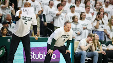 Michigan State coach Tom Izzo watches a play as assistant coach Mark Montgomery holds up a sign