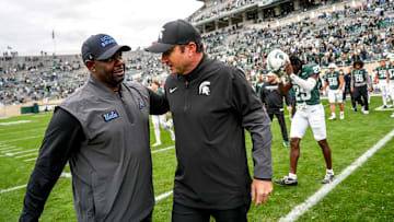 Michigan State's head coach Jonathan Smith, right, meets with UCLA's interim head coach Tim Skipper after the Spartans loss on Saturday, Oct. 11, 2025, at Spartan Stadium in East Lansing.