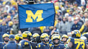 Michigan staffers use a banner to block a TV camera from the Michigan huddle during the second half against Ohio State at Michigan Stadium in Ann Arbor on Saturday, Nov. 25, 2023.