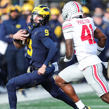 Michigan quarterback J.J. McCarthy runs against Ohio State safety Josh Proctor during the first half at Michigan Stadium in Ann Arbor on Saturday, Nov. 25, 2023.