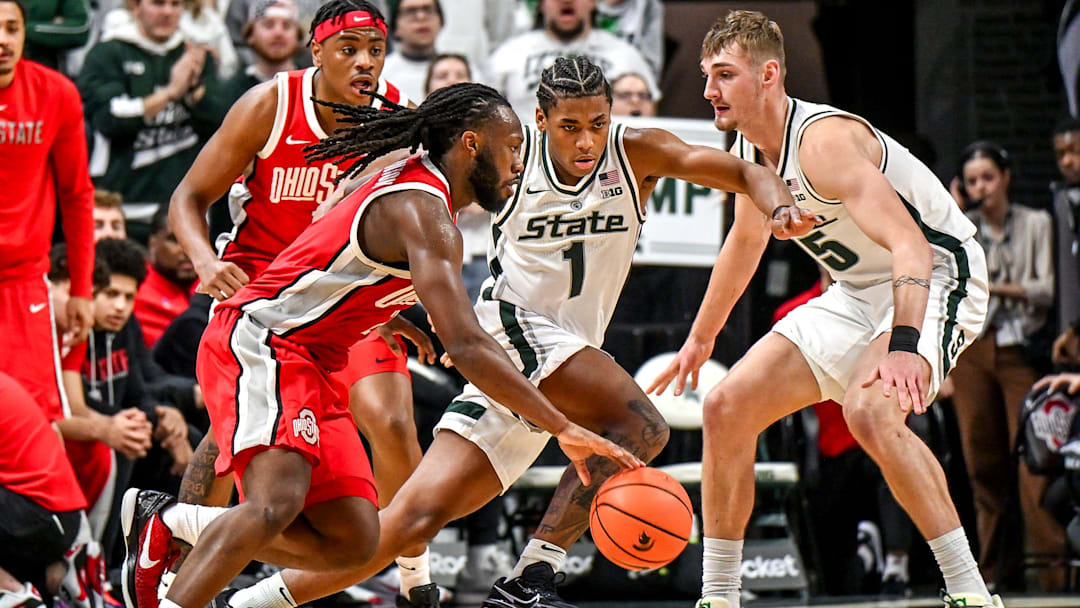 Michigan State's Jeremy Fears Jr., center, defends against Ohio State's Bruce Thornton, left, during the second half on Sunday, Feb. 22, 2026, at the Breslin Center in East Lansing.