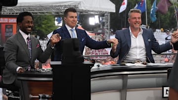 Desmond Howard, left, Rece Davis, Pat McAfee hold hands for a photo before starting live broadcast during ESPN Gameday near Williams-Brice Stadium in Columbia, S.C.