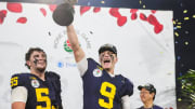 Michigan quarterback J.J. McCarthy lifts the Rose Bowl trophy to celebrate.