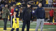 Michigan Wolverines head coach Jim Harbaugh, center, quarterbacks coach Matt Weiss, right, and quarterback Cade McNamara during warmups before action against the Indiana Hoosiers, Saturday, Nov. 6, 2021 at Michigan Stadium.