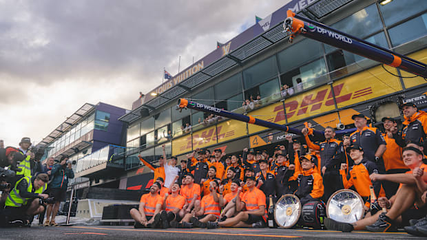 The full McLaren team poses for a picture around drivers Lando Norris and Oscar Piastri. 