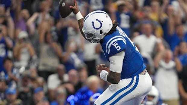 Colts quarterback Anthony Richardson (blue jersey; white pants) jumps in celebration after scoring a touchdown. 