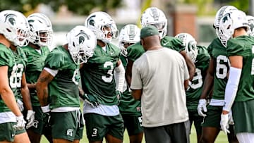 Michigan State's wide receivers gather around coach Courtney Hawkins during the first day of football camp on Tuesday, July 30, 2024, in East Lansing.