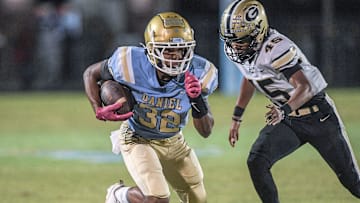 D.W. Daniel High School freshman Trey Wimbley (32) runs near Greer High senior Quamaine Dodd (45) during the first quarter at DW Daniel High School in Central, S.C. Friday, November 1, 2024.