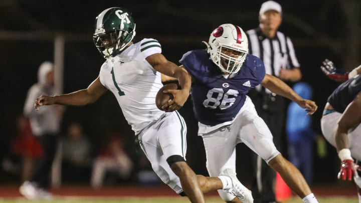 Detroit Cass Tech quarterback Corey Sadler Jr. runs against Westland Glenn's Jermaine Gumbs during the first half of a Division 1 district semifinal at John Glenn High School in Westland on Friday, Oct. 27, 2023.