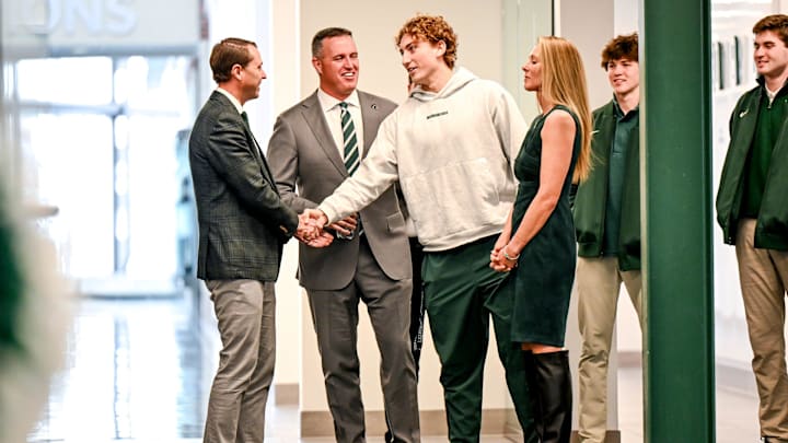 Michigan State's new football coach Pat Fitzgerald, center, and MSU Athletic Director J Batt, left, meets with Spartans quarterback Alessio Milivojevic, right, while waiting for Fitzgerald's introductory press conference to start on Tuesday, Dec. 2, 2025, at the Tom Izzo Football Building in East Lansing.