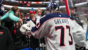 Blue Jackets goalie Jet Greaves gives a fan a puck after warmups