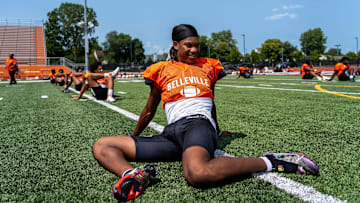 Senior Elijah Dotson, 17, stretches alongside his teammates during a team practice at the Belleville High School football field in Belleville on Wednesday, Aug. 14, 2024.