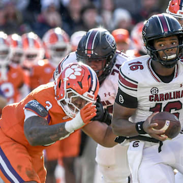 Nov 30, 2024; Clemson, South Carolina, USA; South Carolina quarterback LaNorris Sellers (16) runs away from Clemson defensive end T.J. Parker (3) during the fourth quarter at Memorial Stadium. Mandatory Credit: Ken Ruinard-Imagn Images