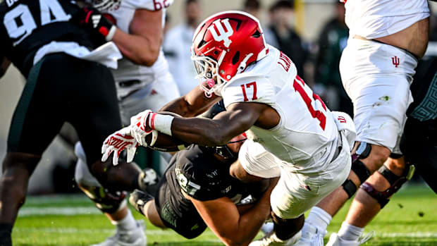 Indiana’s Ty Son Lawton scores a touchdown as Michigan State’s Cal Haladay attempts the tackle.