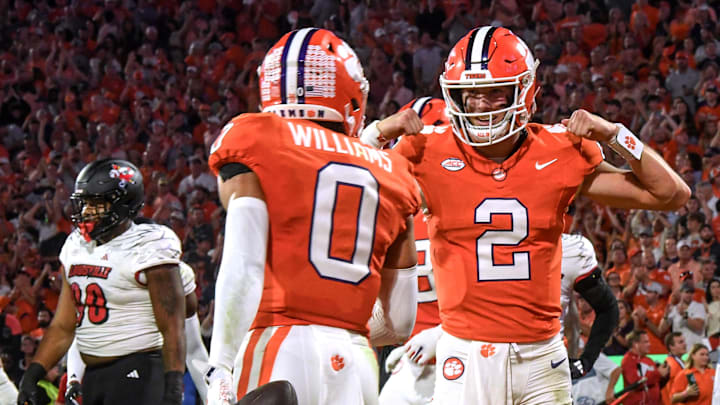 Nov 2, 2024; Clemson, South Carolina, USA; Clemson Tigers quarterback Cade Klubnik (2) celebrates after throwing a touchdown pass to wide receiver Antonio Williams (0) against the Louisville Cardinals during the first quarter at Memorial Stadium. Mandatory Credit: Ken Ruinard-Imagn Images