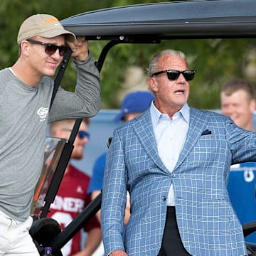 Manning and Jim Irsay watch a Colts practice.
