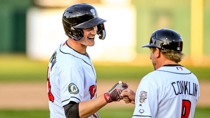 Lugnuts' Will Simpson, left, celebrates his two-run double with manager Craig Conklin during the fifth inning in the game against the Loons on Tuesday, April 9, 2024, at Jackson Field in Lansing.