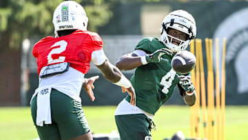 Michigan State running back Elijah Tau-Tolliver, right, gets a pitch from Aidan Chiles during football practice on Monday, Aug. 11, 2025, in East Lansing.