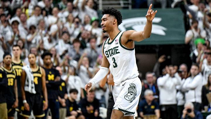 Michigan State's Jaden Akins acknowledges the fans after kissing the Spartans logo before getting subbed out late during the second half in the game against Michigan 
