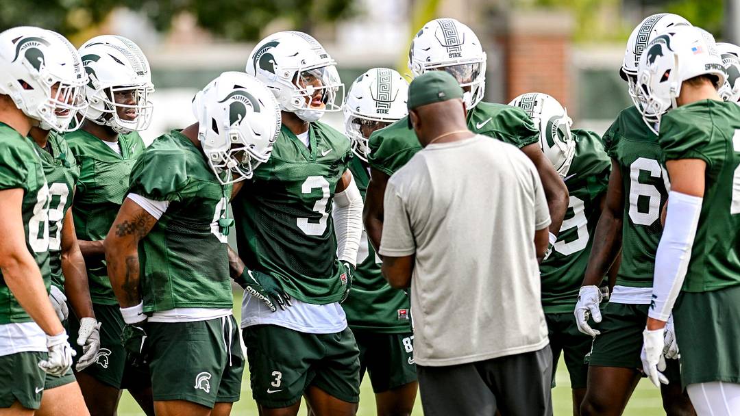 Michigan State's wide receivers gather around coach Courtney Hawkins during the first day of football camp on Tuesday, July 30, 2024, in East Lansing. Michigan State's wide receivers gather around coach Courtney Hawkins during the first day of football camp on Tuesday, July 30, 2024, in East Lansing.