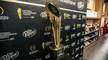 Fans stop to take photos with the College Football National Championship trophy at Meijer in Ypsilanti, Mich. on Thursday, Jan. 11, 2024. The trophy is going on a tour for fans to see presented by Dr. Pepper.