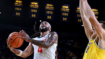 Mar 2, 2025; Ann Arbor, Michigan, USA;  Illinois Fighting Illini guard Kylan Boswell (4) drives to the basket past Michigan Wolverines center Vladislav Goldin (50) in the second half at Crisler Center. Mandatory Credit: Lon Horwedel-Imagn Images