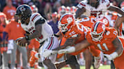 Nov 30, 2024; Clemson, South Carolina, USA; South Carolina quarterback LaNorris Sellers (16) runs by Clemson defensive tackle Payton Page (55) and defensive lineman Peter Woods (11) during the fourth quarter at Memorial Stadium. Mandatory Credit: Ken Ruinard-Imagn Images