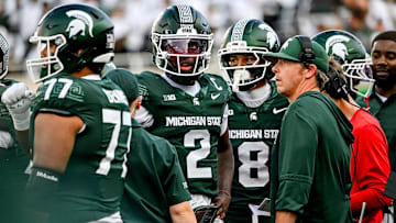 Michigan State's Aidan Chiles, left, and quarterbacks coach Jon Boyer meet on the sideline during the fourth quarter in the game against Youngstown State on Saturday, Sept. 13, 2025, at Spartan Stadium in East Lansing.