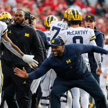 Michigan co-offensive coordinator Sherrone Moore high fives running back Donovan Edwards (7) after Edwards's scored a touchdown against Ohio State during the second half Nov. 26, 2022 at Ohio Stadium in Columbus.